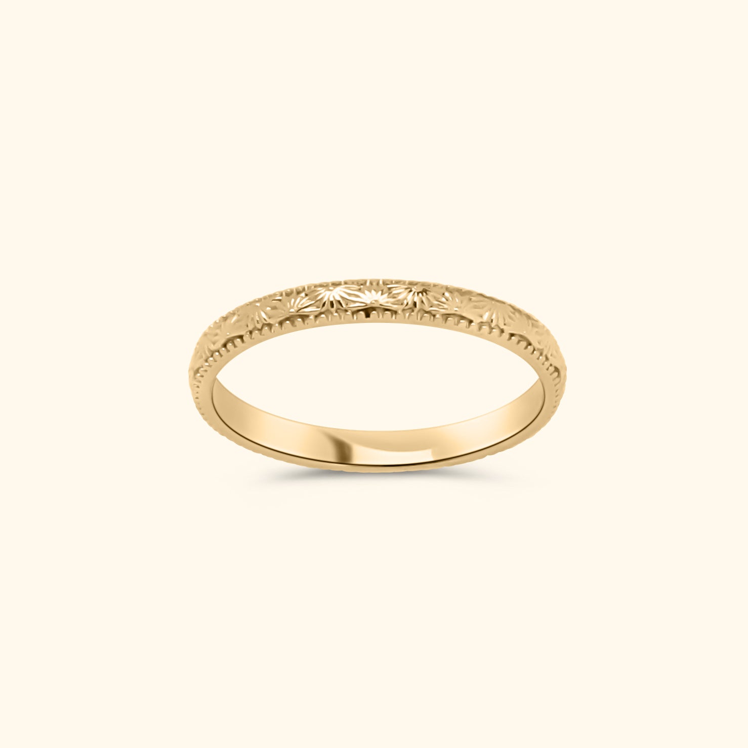 Goudkleurige stapelring van gold plated messing met subtiel gegraveerd zon- en bloemenpatroon.